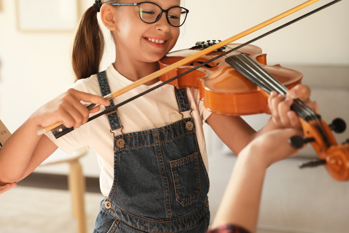 Young violin student smiling during a lesson